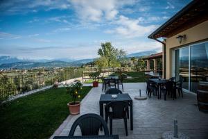 un patio con tavoli e sedie e vista di Agriturismo il Grappolo a Lazise