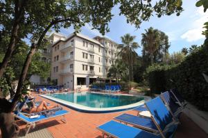 a hotel with a swimming pool with people laying on chairs at Hotel Caravel in Sant'Agnello