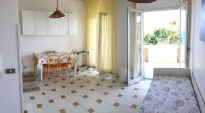 una cucina con tavolo e una sala da pranzo con finestra di Le Zagare apartments a SantʼAlessio Siculo