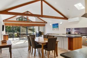 a kitchen and dining room with a wooden table and chairs at Sea Foam Villas in Port Campbell