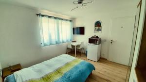 sypialnia z łóżkiem i stołem z kuchenką mikrofalową w obiekcie Chambre d'hôte "Minergy" w mieście Donatyre