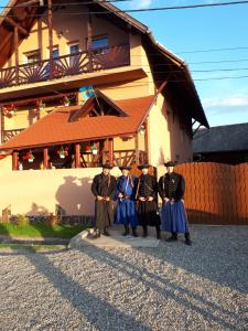 un grupo de personas de uniforme parados frente a un edificio en Lörincz Vendégház, en Corund