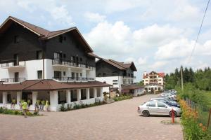a large building with cars parked in a parking lot at Hotel Miruna in Sîmbăta de Sus