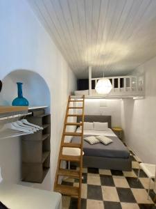 a small bedroom with a bunk bed and a ladder at Bougainvillea Friends & Family Studio - Old Town in Mikonos
