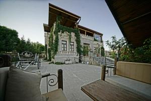 a patio with benches and a building with ivy at Alaturca House in Göreme