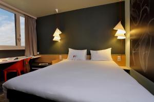 a hotel room with a large bed and two lamps at ibis Le Mans Est Pontlieue in Le Mans