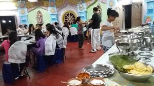 grupa ludzi w pokoju z jedzeniem na stole w obiekcie Kishkinda Heritage Resort w mieście Hampi