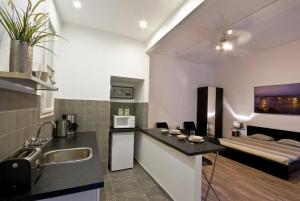 una cocina con encimera y una cama en una habitación en Daphne Deluxe Apartment, en Budapest 15 fotos más