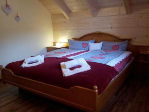 1 dormitorio con 1 cama grande de madera y toallas. en Zimmer im Lungau, en Sankt Michael im Lungau