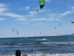 deux personnes sur la plage volant des cerfs-volants dans l'océan dans l'établissement Belchevi Apartments, à Bourgas