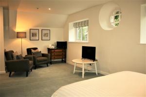 a bedroom with a bed and a tv and a table at The Coach House in Windermere