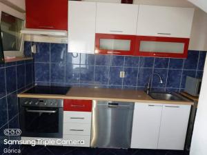 una cocina con armarios rojos y blancos y fregadero en Villa Gorica Apartments Ražanj en Ražanj
