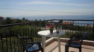 stół i 2 krzesła na balkonie z widokiem na ocean w obiekcie Yianna Studios & Apartments w mieście Gerakini