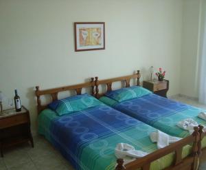 a bedroom with a blue bed with two pillows at Yianna Studios & Apartments in Gerakini