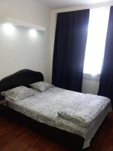- un petit lit dans une chambre avec fenêtre dans l'établissement Nuri Hotel Стадион, à Karaganda