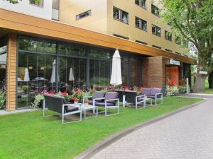 a building with chairs and a table with an umbrella at Fletcher Wellness-Hotel Stadspark in Bergen op Zoom