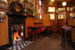 a bar with a fireplace and chairs in a room at Victoria inn in Durham