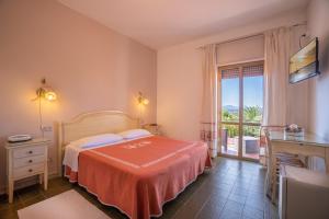 ein Schlafzimmer mit einem Bett und einem großen Fenster in der Unterkunft Hotel Casa Mia in Arzachena