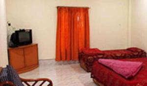 ein Wohnzimmer mit roten Möbeln und einem TV in der Unterkunft TG Resort in Nāmdāng