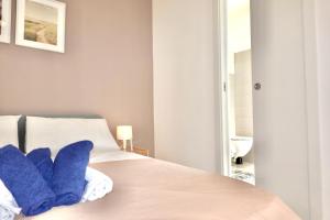 a bedroom with a bed with blue pillows on it at Villa OPLONTI - tra Napoli, Pompei e Sorrento in Torre Annunziata