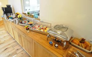 a counter with a buffet with bread on it at Blekkers Bed&Breakfast in Uelsen