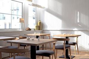 a restaurant with tables and chairs and a window at Hotel Aquamarin in Norderney