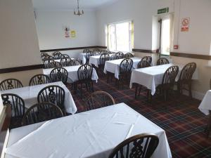 um grupo de mesas e cadeiras numa sala em Elmhurst Hotel em Reading