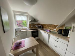 a kitchen with white cabinets and a table and a window at Haus Petersen in Undeloh