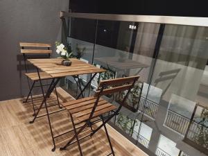 a wooden table and chairs on a balcony at Desiran @ Timurbay - seafront studio apartment with WiFi in Kuantan