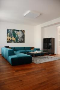 a living room with a blue couch and a table at Premium apartment near Banská Bystrica square with two big bedrooms in Banská Bystrica