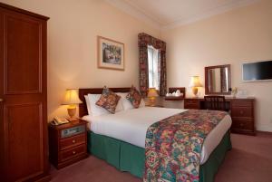 a hotel room with a bed and a tv at Ashley Hotel in Cambridge