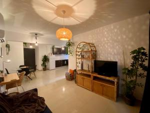 a living room with a television and a dining room at Fat Cow Apartment 102 in Livadhia