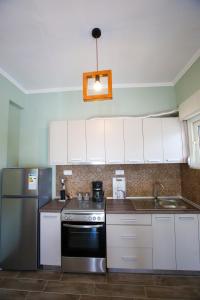 eine Küche mit weißen Schränken und einem Kühlschrank aus Edelstahl in der Unterkunft Stella boutigue rooms in Néa Péramos