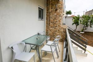 einen Tisch und Stühle auf dem Balkon eines Hauses in der Unterkunft Stella boutigue rooms in Néa Péramos