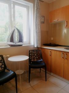 cocina con mesa, 2 sillas y ventana en Apartament Legionów 55, en Gdynia