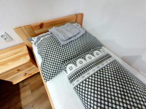 a bed with black and white sheets in a room at U Mlynára in Ružomberok