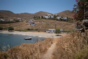 um pequeno barco na água ao lado de uma praia em House by the sea em Kythnos