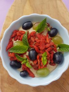 a bowl of food with berries and mint on a table at Le Domaine des Prés in Lachambre