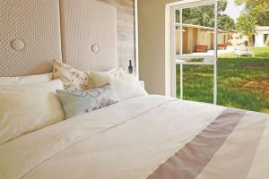 a bedroom with a white bed and a window at Eretz Zeelim in Ẕeʼelim