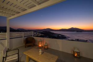 balcón con mesa y vistas al océano en Lorenzo Studios and Suites Paros en Naousa