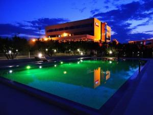 a large swimming pool in front of a building at night at Hotel Panorama in Šibenik