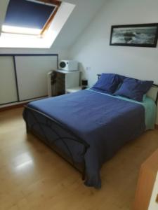 - une chambre avec un grand lit et des oreillers bleus dans l'établissement Gilles Diais, à Louisfert