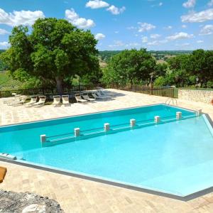 una piscina con sedie e un albero di Trulli Panoramici ad Alberobello