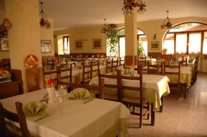 a restaurant with tables and chairs with white tablecloths at Albergo Ristorante Sole in Mezzoldo