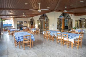 a restaurant with blue and white tables and chairs at West End Hotel in Peyia