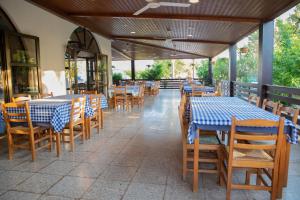 an empty restaurant with blue tables and chairs at West End Hotel in Peyia