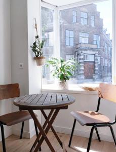 a wooden table and two chairs in front of a window at Cosy Tiny House 5 min walk Keukenhof included entrance keukenhof in Lisse