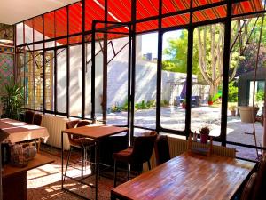 ein Restaurant mit Tischen und Stühlen und einem großen Fenster in der Unterkunft Le 3 fuscien in Amiens