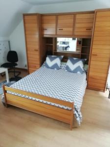 - une chambre avec un grand lit et des oreillers bleus dans l'établissement Gilles Diais, à Louisfert