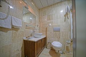 a bathroom with a toilet and a sink and a shower at Alaturca House in Göreme +225 photos